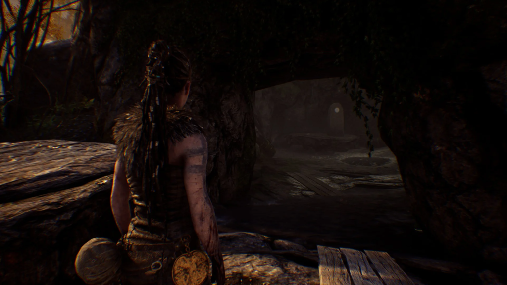 Сенуа из Hellblade стоит у входа в пещеру