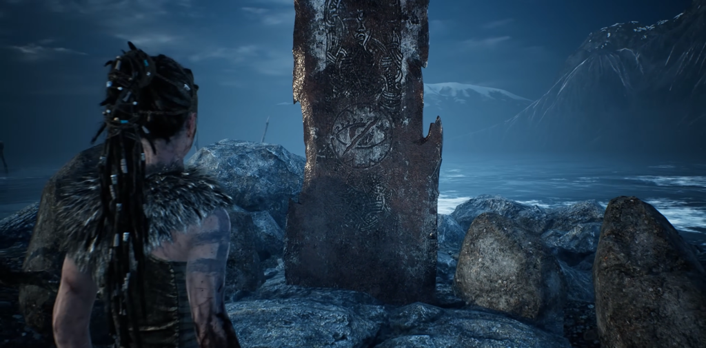 Сенуа из Hellblade смотрит на рунический камень у моря