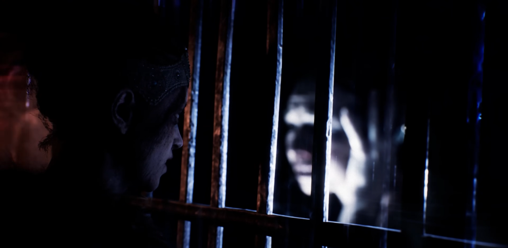 Мужчина смотрит через решётку на лицо в темноте