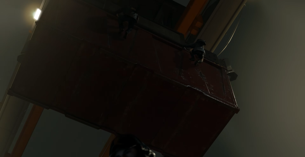 Два человека карабкаются по красному контейнеру в помещении