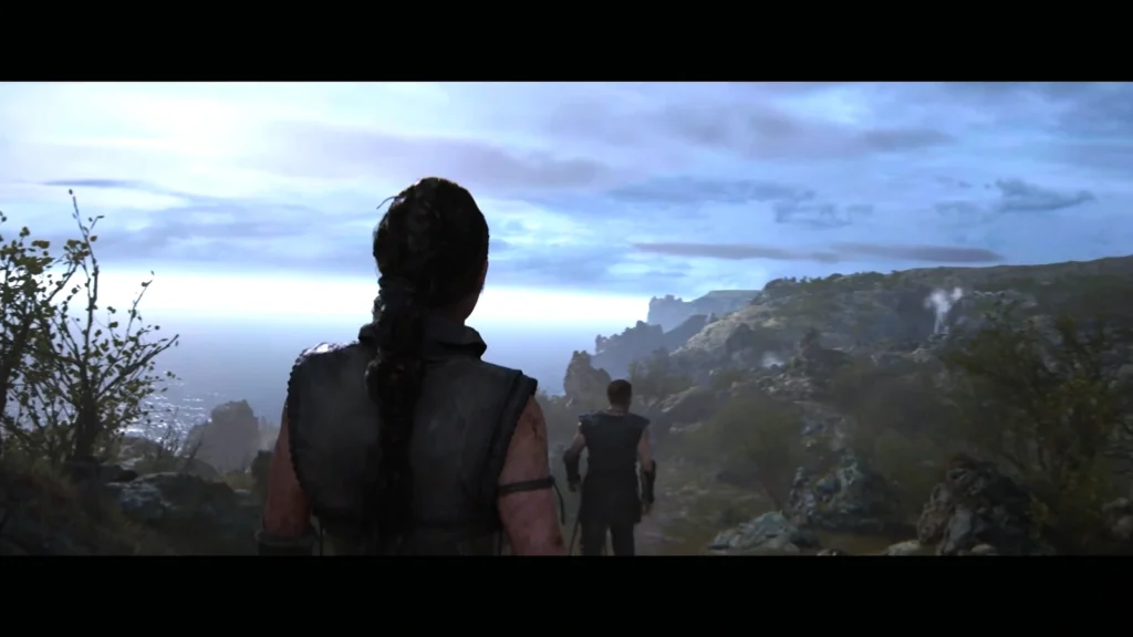 Два человека идут по горной тропе у моря