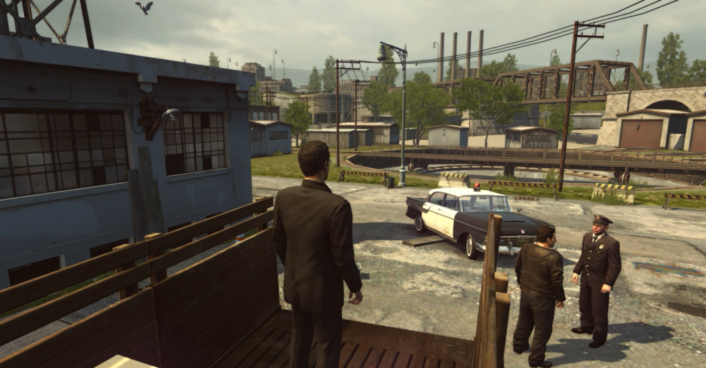 Персонаж Mafia II стоит у полицейской машины во дворе