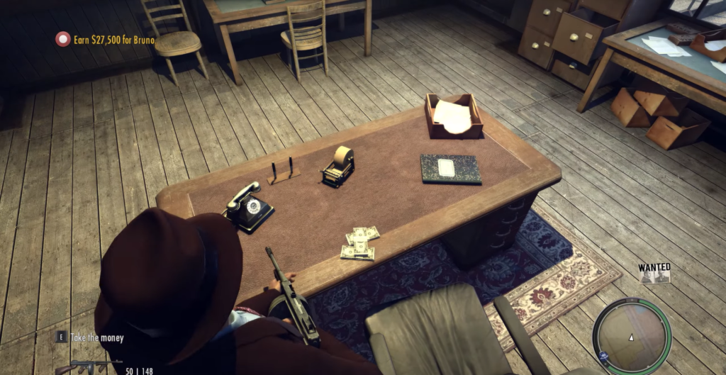 Персонаж Mafia II держит пистолет у офисного стола