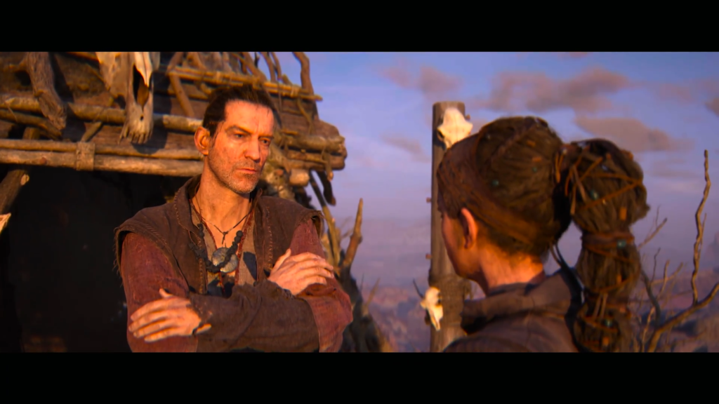 Мужчина разговаривает с женщиной у деревянной хижины