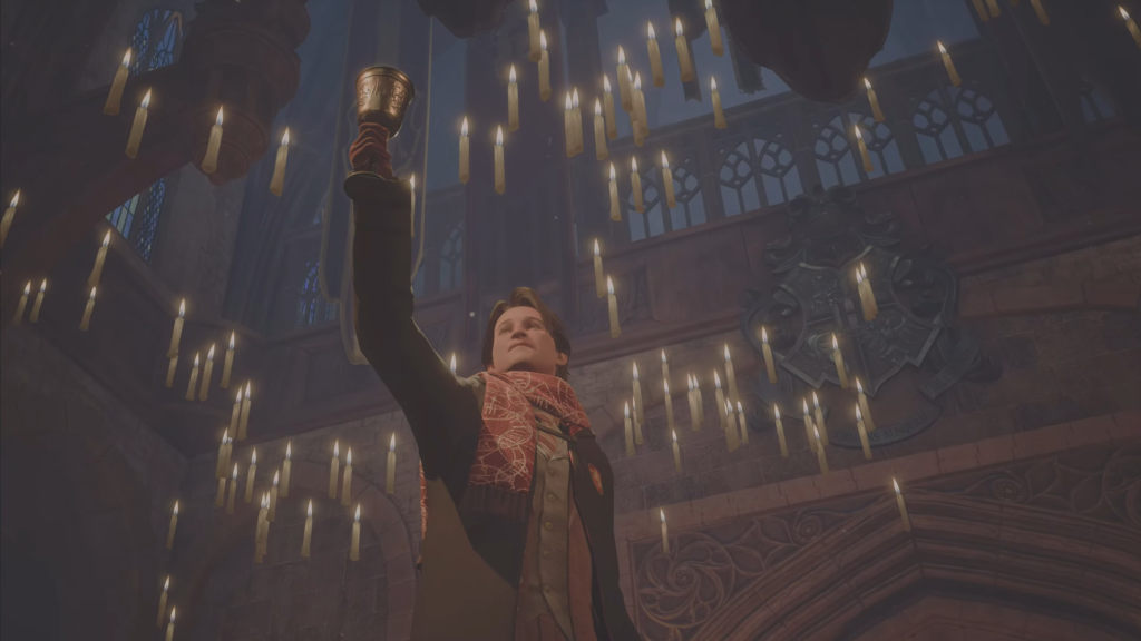 Ученик Хогвартса поднимает кубок в Большом зале