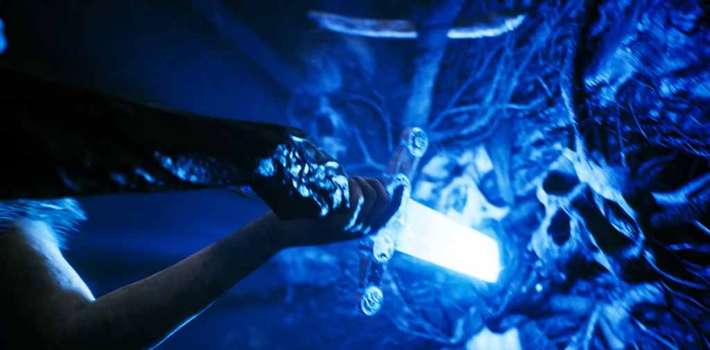 Рука в перчатке держит светящийся меч у черепа