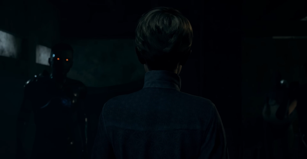 Мальчик стоит спиной в тёмной комнате