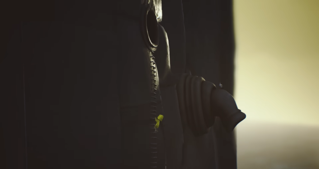 Жёлтая фигурка карабкается по молнии на куртке