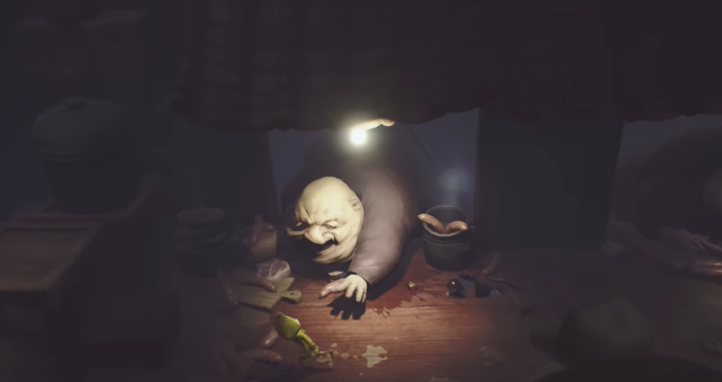 Повар из Little Nightmares тянется через стол кухни