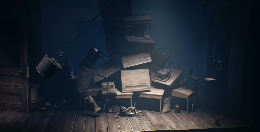 Шестой из Little Nightmares II ползёт среди ящиков в комнате