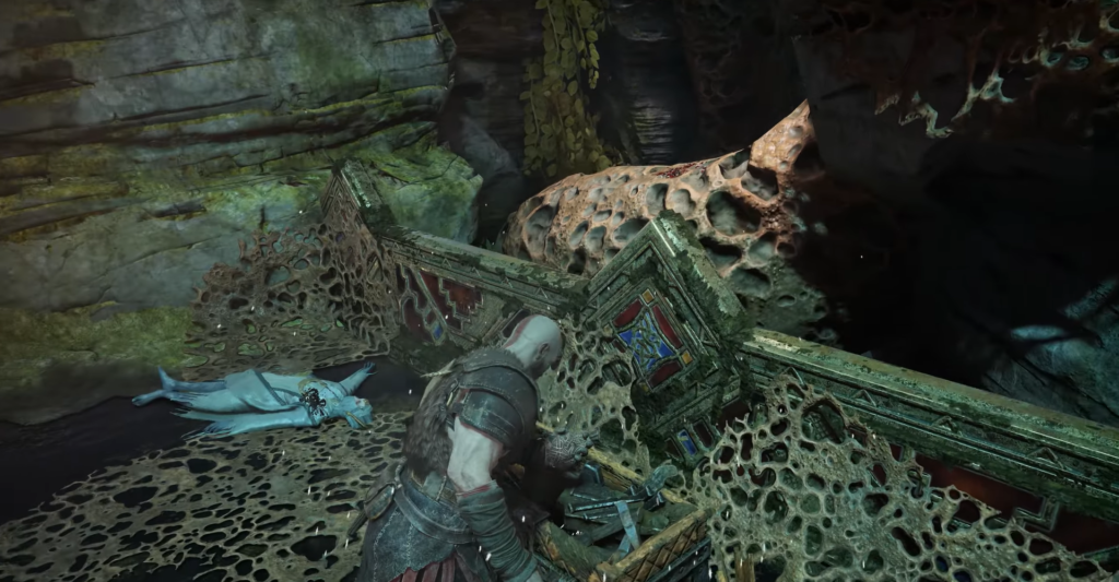 Кратос из God of War открывает сундук в пещере