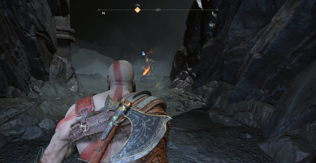 Кратос с топором идет по каменному ущелью God of War