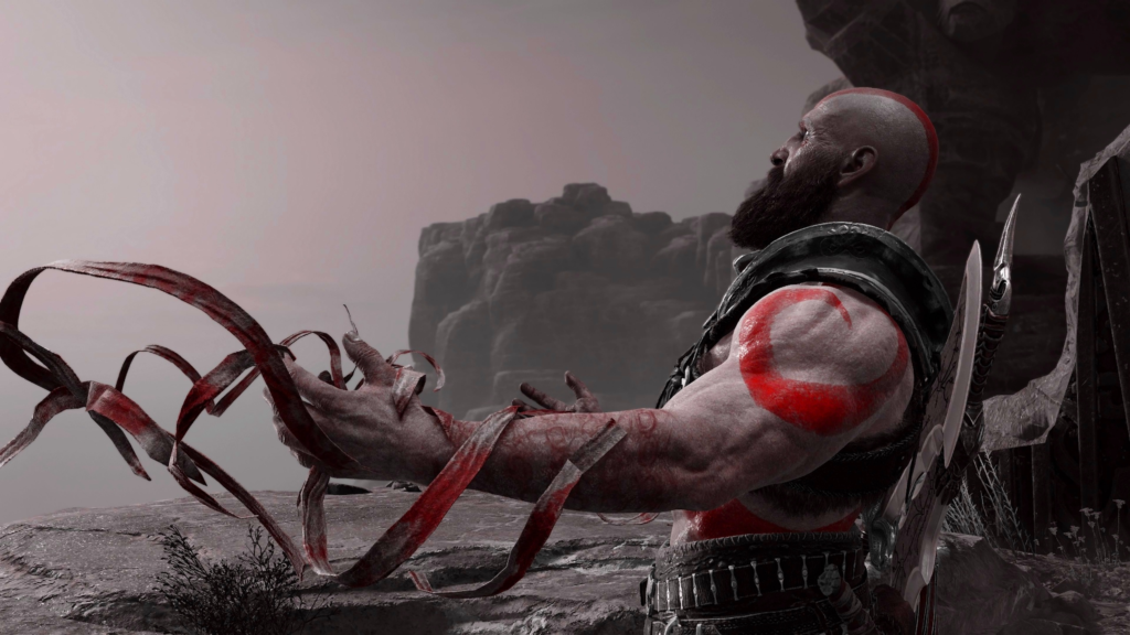 Кратос из God of War держит красные ленты на скалах