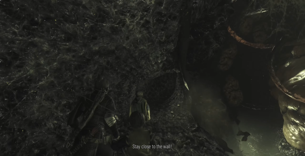 Персонажи идут вдоль стены в пещере с паутиной